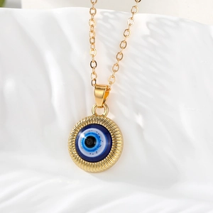 Vue macro du pendentif œil maléfique doré avec émail bleu et textures radiales