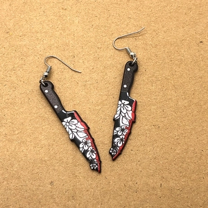 Detailed shot of Gothic cleaver earrings with floral print and red blood edge details