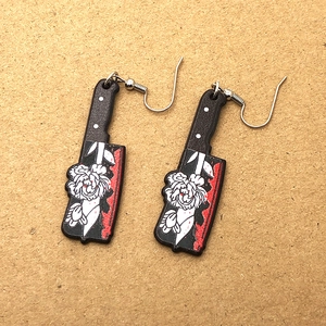 Detailed shot of Gothic acrylic cleaver earrings with blood splatters and white floral pattern
