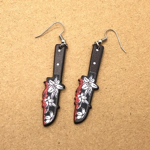 Gothic skull dagger earrings with blood splatter and white flower patterns on black blades