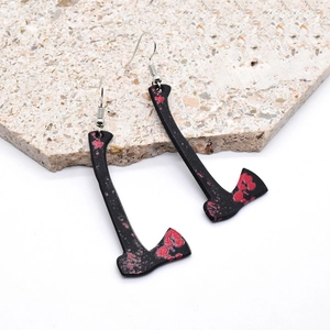 Close-up of gothic Halloween acrylic earrings featuring a blood-stained black axe design