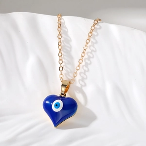Dettaglio del ciondolo a cuore in smalto blu malocchio su una catena dorata a maglia O