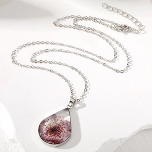 Handmade teardrop purple dried flower necklace in clear resin with silver chain