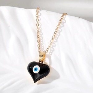 Collana a catena dorata con pendente a cuore nero e motivo mistico del malocchio