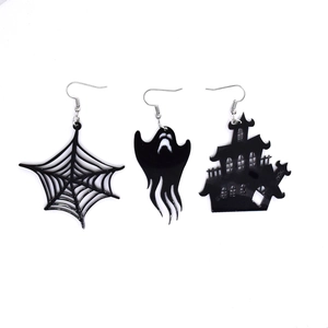 Detailed macro view of Halloween acrylic earrings featuring spider web and ghost designs