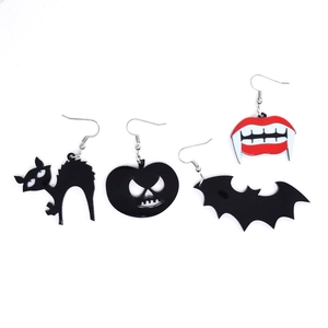 Detailed macro view of acrylic Halloween earrings featuring pumpkin, bat, and cat charms