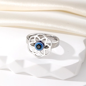 Détail du design de pétale de fleur creux et de la perle œil bleu sur une bague en argent