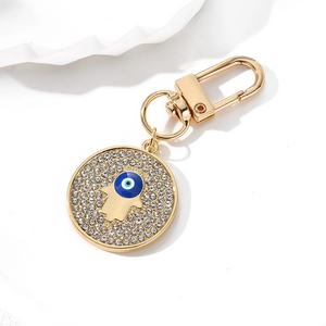 Vintage gold devil eye keychain with sparkling rhinestones and Hamsa hand symbol