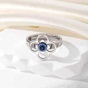 Bague vintage argentée trèfle creux avec œil bleu sur fond en soie blanche élégante