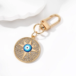 Macro detail of golden evil eye keychain with blue crystals and sparkling rhinestones