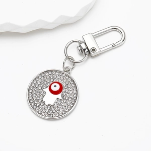 Macro view of silver Hamsa Hand and Evil Eye charm keychain with sparkling rhinestones