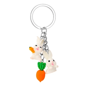 Detail of cute resin white rabbit charms with small carrot pendants on silver keychain