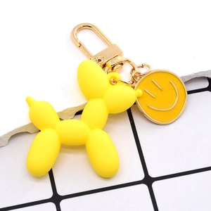 Dettaglio del portachiavi a forma di cane palloncino giallo con chiusura dorata