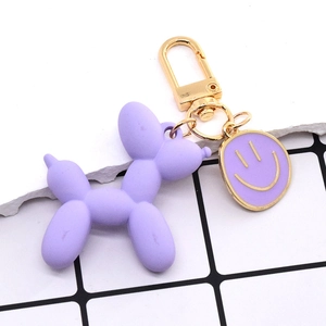Portachiavi cane palloncino viola opaco con hardware dorato e ciondolo con faccina sorridente