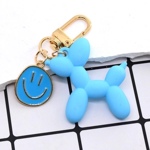 Dettaglio portachiavi a cane palloncino blu opaco con gancio dorato e ciondolo sorridente
