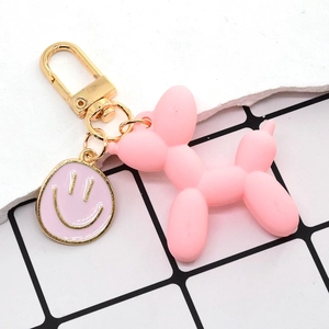 Dettaglio portachiavi a forma di cane palloncino rosa opaco con gancio dorato e smiley