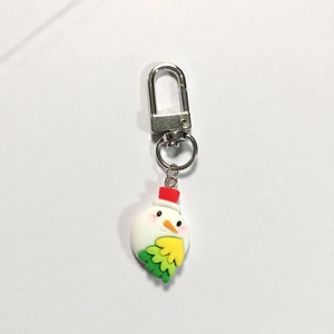 Close-up of a cute cartoon snowman keychain with a red hat and silver metal lobster clasp