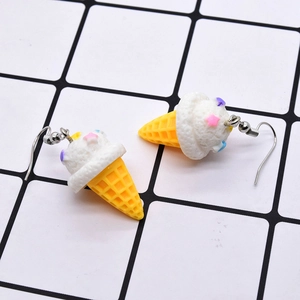 Detail of creative ice cream cone earrings with colorful star sprinkles and yellow cone texture