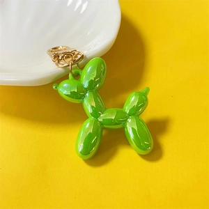 Detail of glossy green balloon dog charm with shiny metallic finish and gold keyring