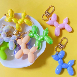 Macro shot of colorful metallic balloon dog keychains with golden spring clips