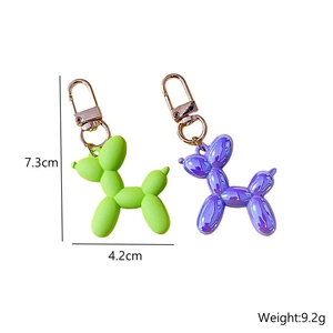 Balloon dog keychain in matte green and metallic purple with size and weight specs