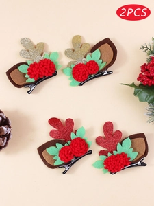 Close-up of glittery reindeer antler hair clips with red pompoms and green leaves