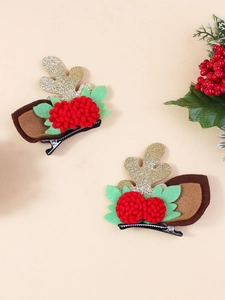 Close-up of glittery reindeer antlers and red pompom flowers on plush hair clips