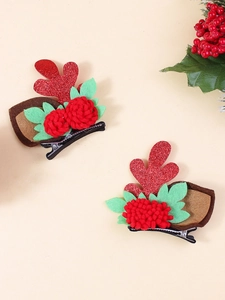 Close-up of Christmas hair clips with red glitter antlers and plush pompom flower detail