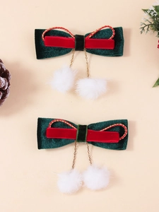 Détail de barrettes à cheveux nœud en velours de Noël avec chaînes dorées et pompons blancs