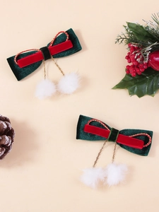 Détail de nœuds de Noël en velours rouge et vert avec pompons blancs et chaînes dorées