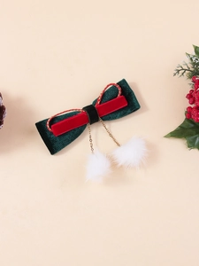 Détail de la pince à cheveux de Noël avec velours vert, bords dorés et pompons en fourrure