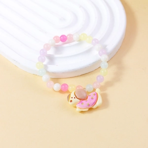 Detail eines bunten Perlenarmbands mit süßem Hundeanhänger für Kinder und Mädchen