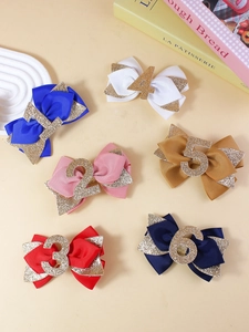 Détail de six barrettes à nœuds avec chiffres pailletés en plusieurs couleurs pour filles