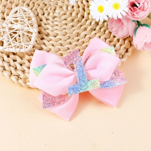 Dettaglio del fermaglio a fiocco rosa glitterato numero 1 per il primo compleanno bimba