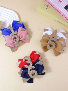 Détail de trois barrettes nœuds à chiffres pailletés pour filles sur un décor de livres
