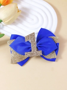 Détail du nœud bleu royal pailleté avec le chiffre un doré pour le premier anniversaire