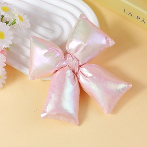 Close-up of a pink iridescent bow accessory with soft aurora metallic finish