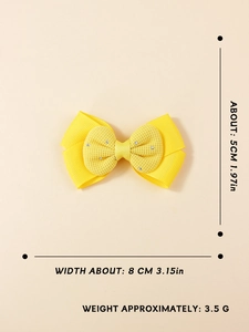 Vue détaillée du nœud à cheveux jaune montrant la largeur de 8 cm et le centre en strass