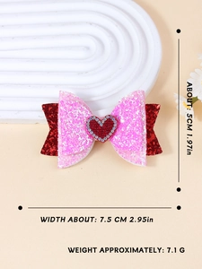 Dettaglio del fiocco per capelli glitterato con paillettes rosa e cuore di strass rossi