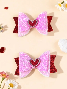 Dettaglio di fermagli per capelli glitter rosa con cuore di strass rossi per bambini