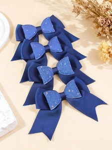 Detail of four navy blue glitter layered bow hair clips with grosgrain ribbon texture