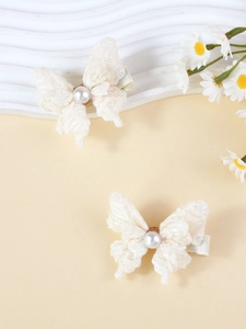 Gros plan détaillé de barrettes à cheveux en dentelle crème avec perles et fleurs