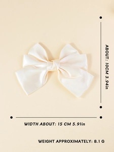 Detail view of cream oversized satin bow hair clip measuring 15cm by 10cm and 8.1g