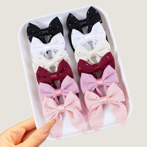 Set of 12 sparkling bow hair clips in multiple colors on a premium display tray