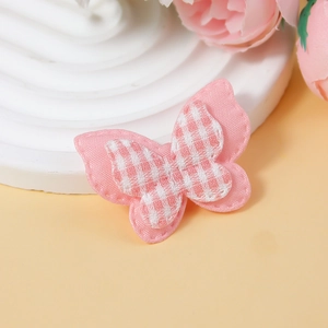 Detail of a pink checkered fabric butterfly accessory for DIY hair clips and clothing