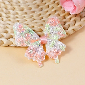 Close-up of glittery pink and green gradient butterfly patch for DIY hair accessories