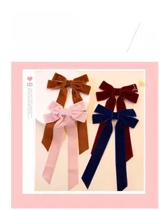 Close-up of velvet hair bow clips in brown, pink, burgundy and navy blue tones