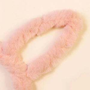 Gros plan du matériau rose doux d'un serre-tête lapin en peluche épaisse