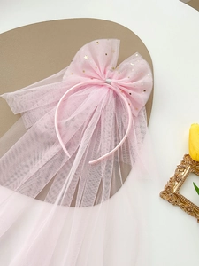 Detail of pink mesh bow headband with golden star moon sequins and flowing long veil