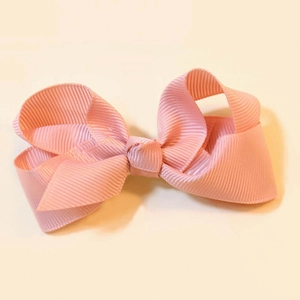 Détail d'un nœud en ruban gros-grain rose clair avec texture côtelée et couches multiples